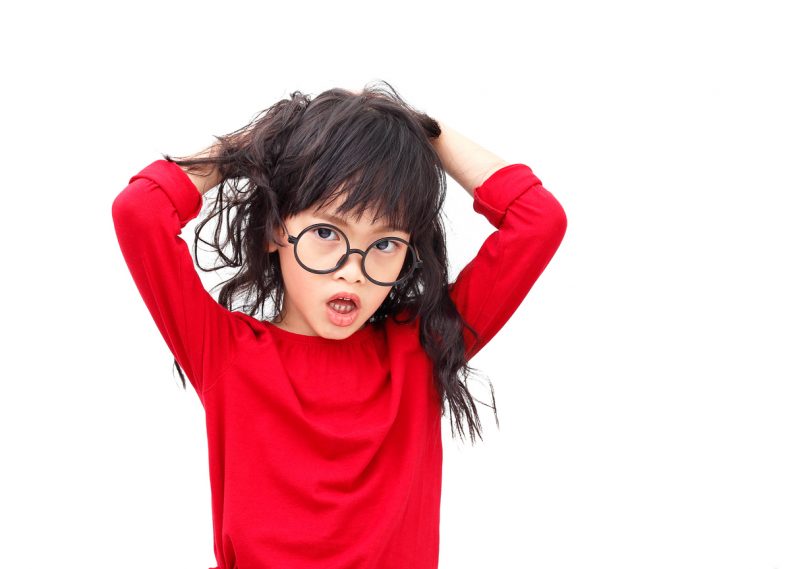 asian little girl  crazy furious pulling messy hair on white background